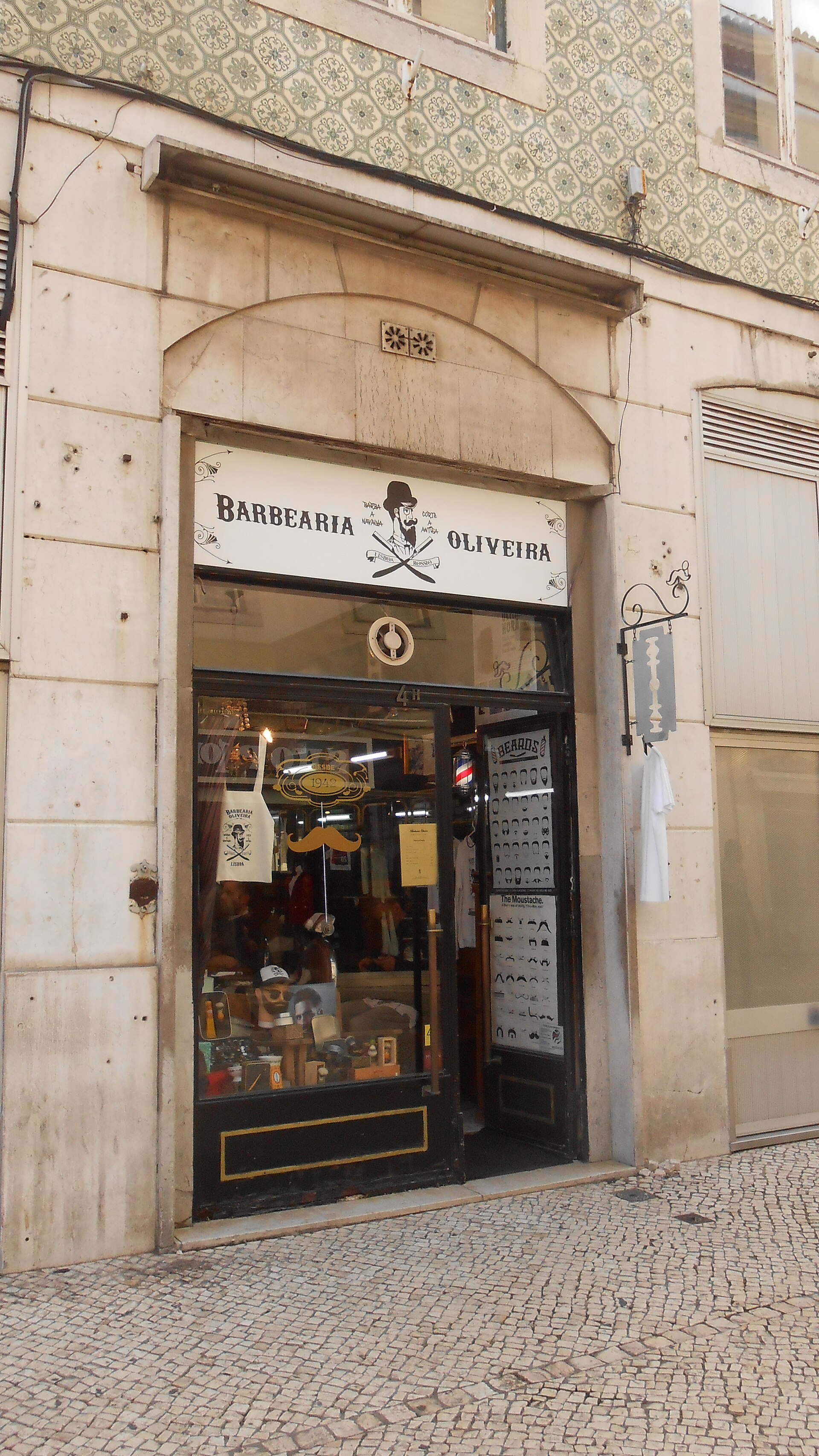 Fachada da Barbearia Oliveira com letreiro pintado à mão e azulejos