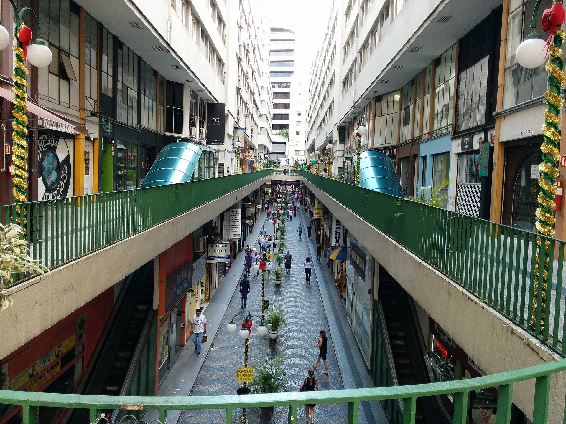 Rua comercial do Centro de São Paulo com lojas de rua, viaduto e pedestres